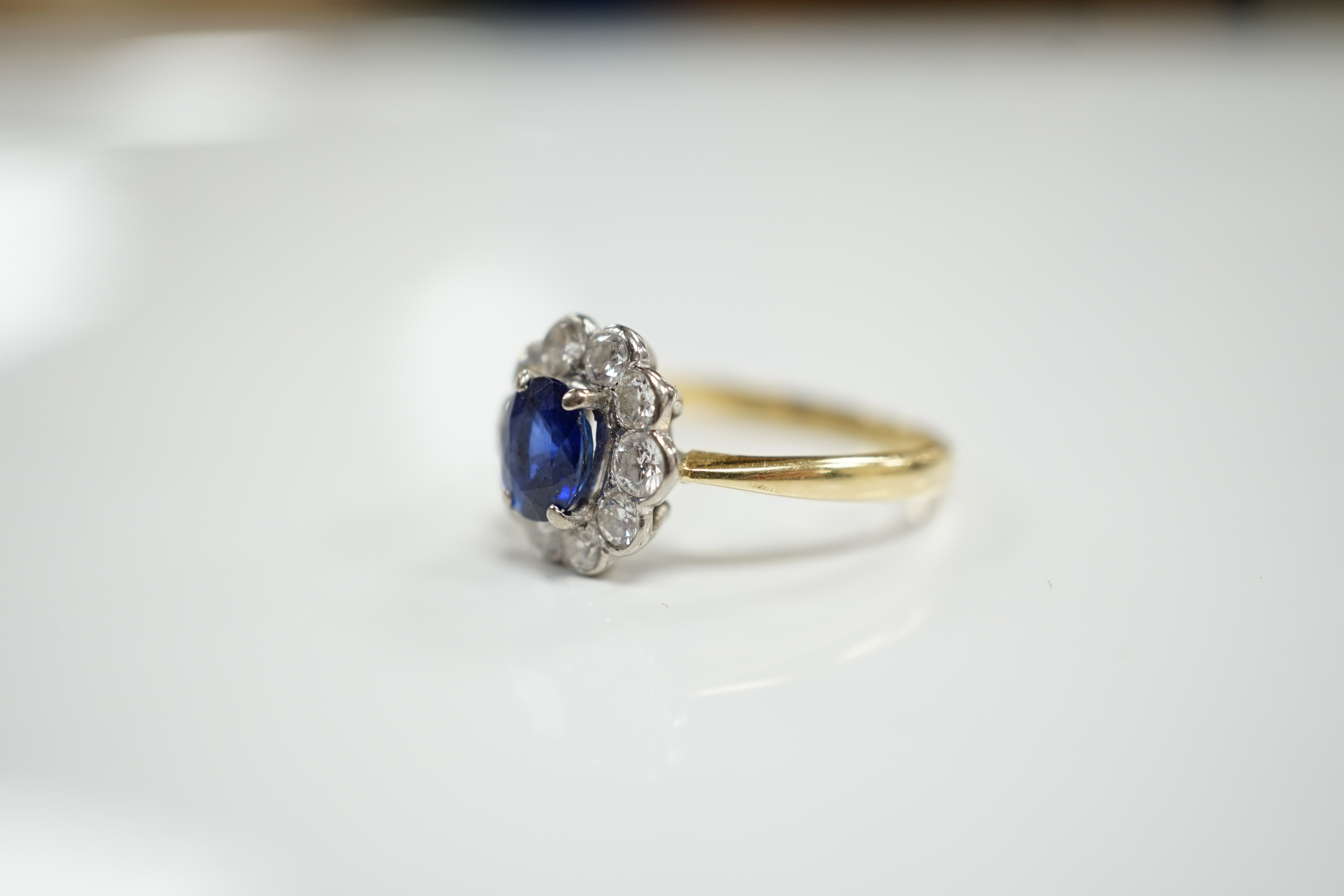 A modern 18ct gold, sapphire and diamond set circular cluster ring, size P/Q, gross weight 3.8 grams.